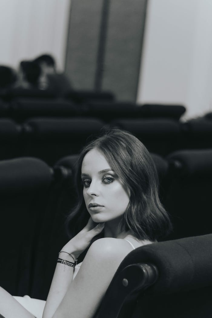 Graceful woman posing indoors in a black and white photograph capturing elegance and style.